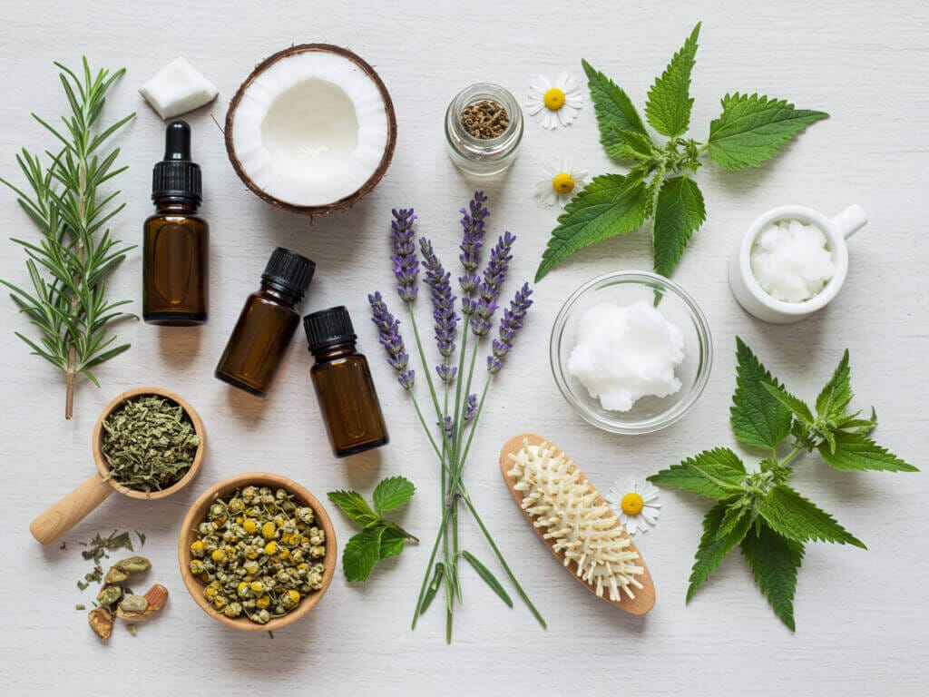 Natürliche Hausmittel für Haarpflege: Kräuter, ätherische Öle und Kokosöl als Zutaten gegen Haarausfall.